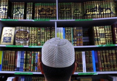 Man wearing an Islamic prayer cap, or "Kufi", looks at Islamic books on display at a bookshop located in the western Sydney suburb of Lakemba